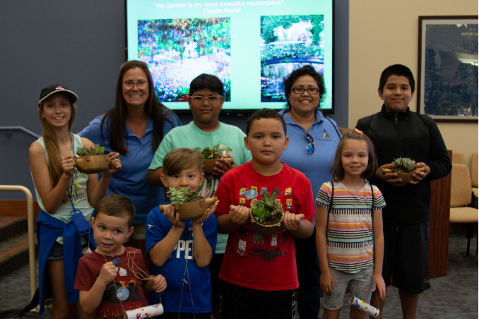 Kids holding up succulent plants 